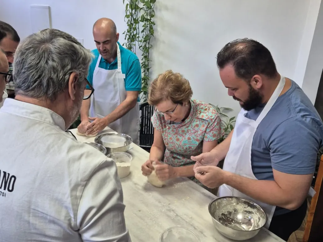 Alumnos formando bolas de masa en la mesa mientras Vera los guía.
